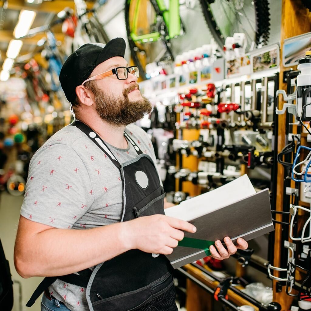 bicycle mechanic with notebook in bike shop pwnd6ab.jpg
